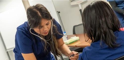 Two students taking blood pressure at the Workforce Development Hub